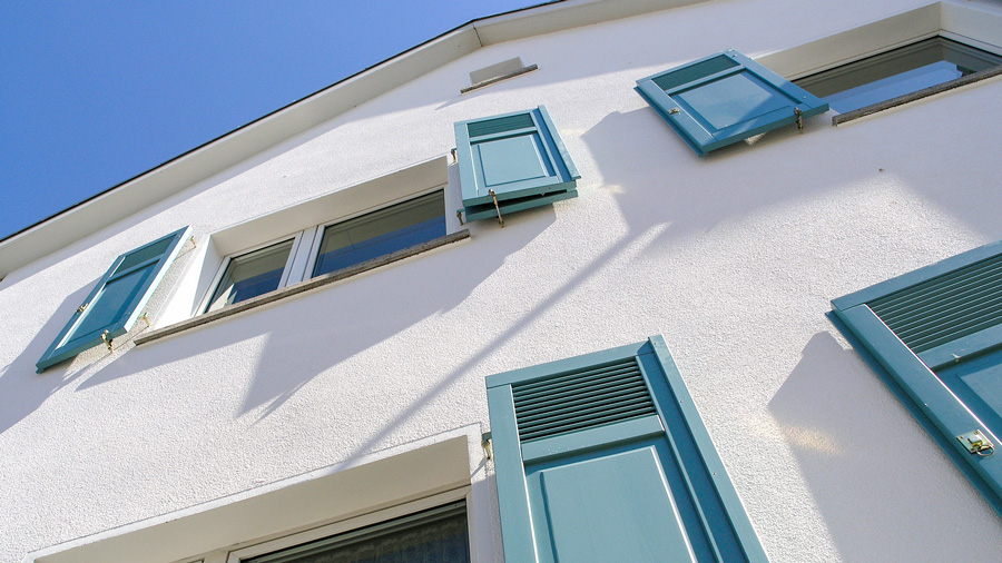 Neuer Putz in weiß für ein Einfamilienhaus mit blauen Fensterläden in Frankfurt